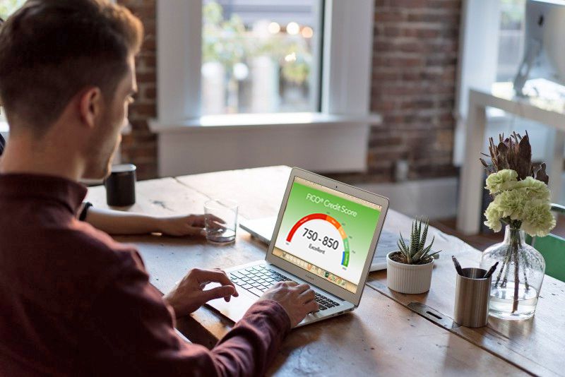 Person checking an excellent credit score on a laptop